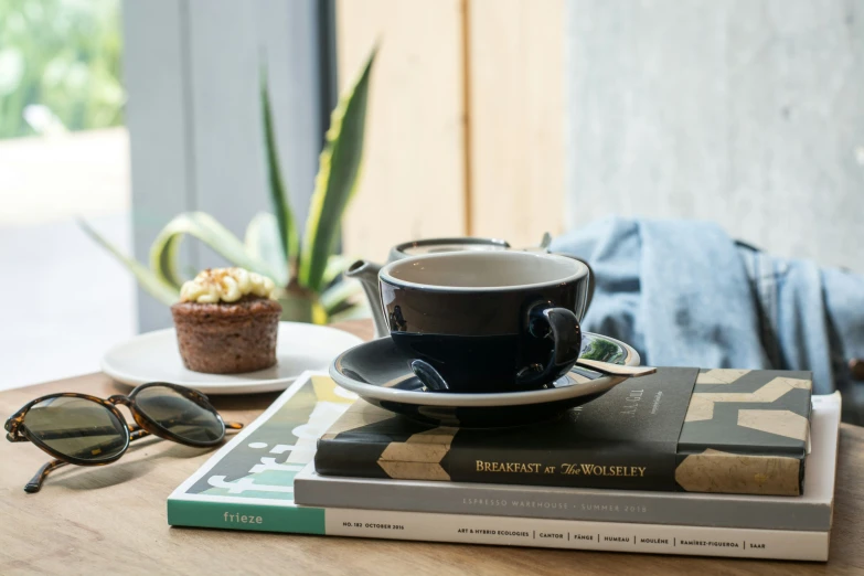 there is a coffee cup on top of some books