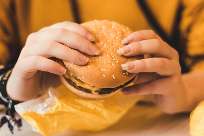 a person is holding a hamburger in their hands