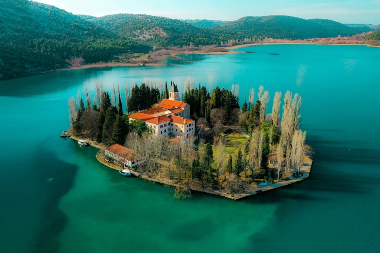 a small island with a building near a forest