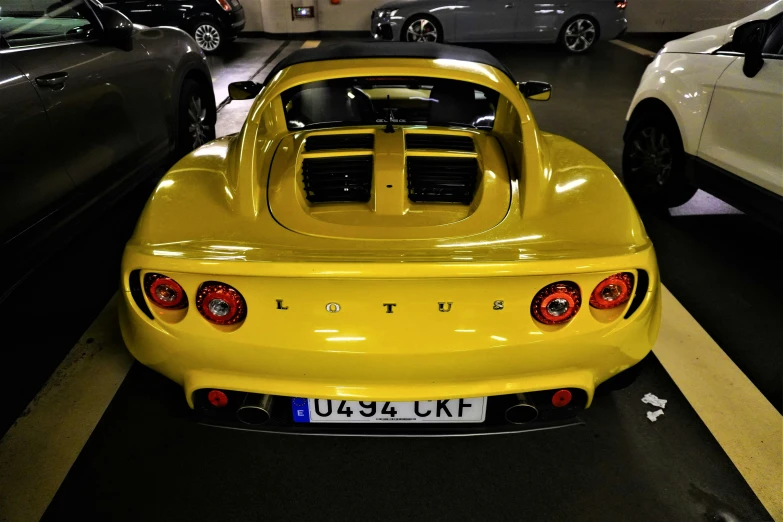 a yellow sports car parked in a parking garage