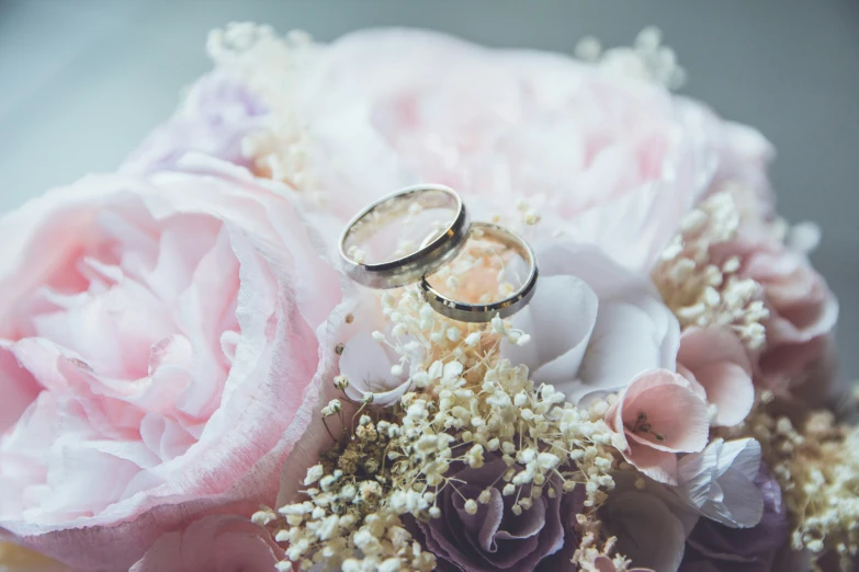 two wedding rings on flowers with more petals