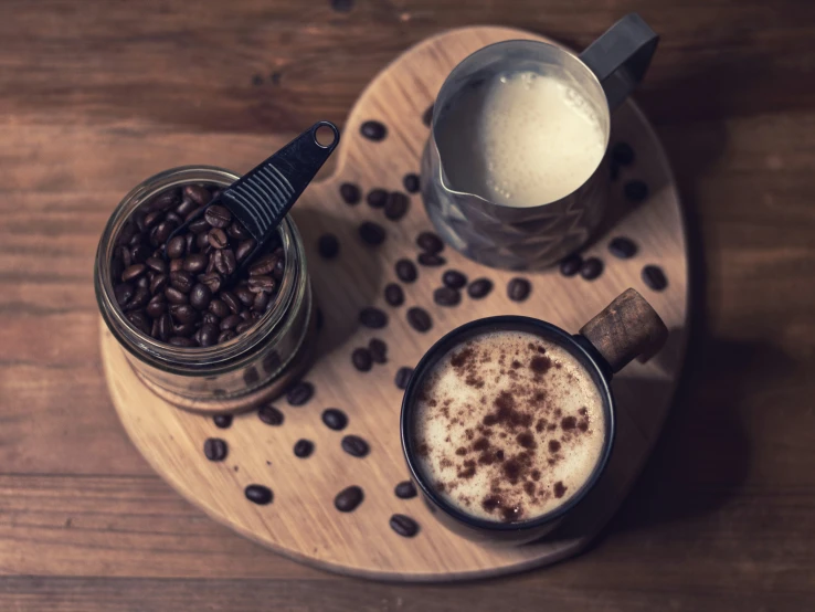 two cups of coffee and coffee beans on a plate