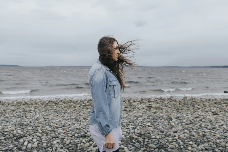 the back view of a woman looking out at the ocean