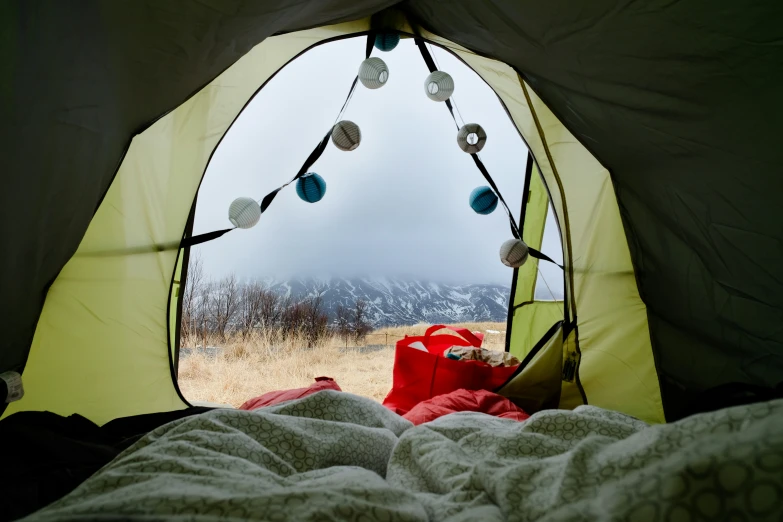 a tent with the interior open and two people sleeping in it