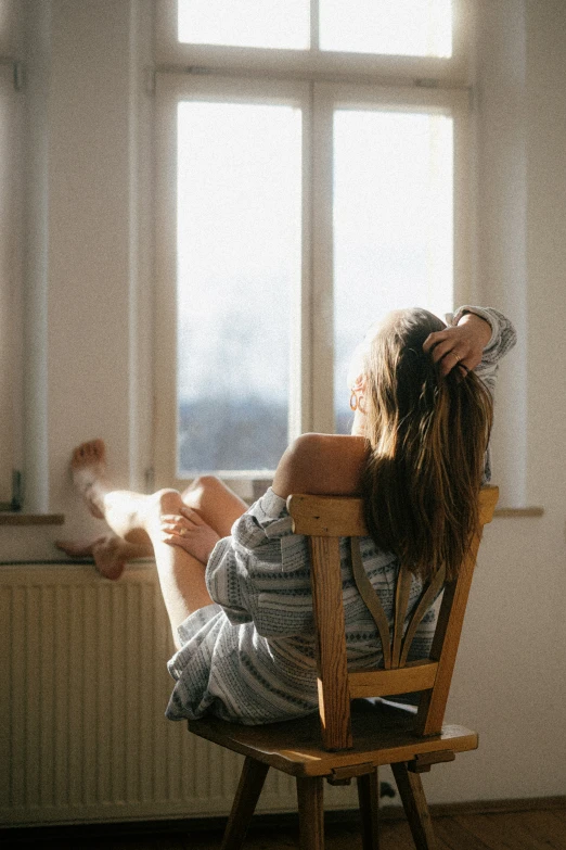 young woman sitting in a chair watching the sun set