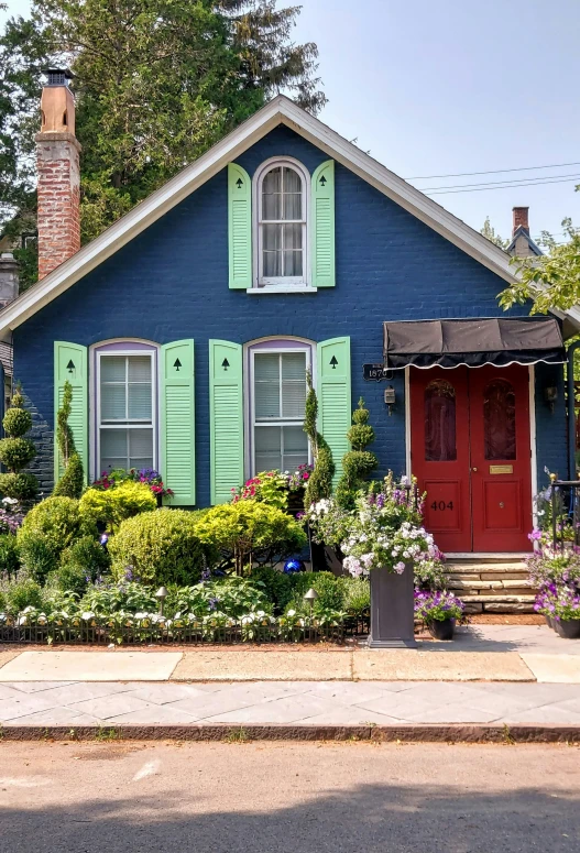 a house painted in blue and green with a red door