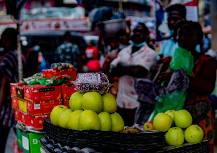 a person at a market with fruit in the foreground