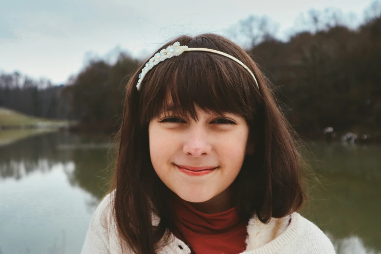 a smiling  in front of a lake