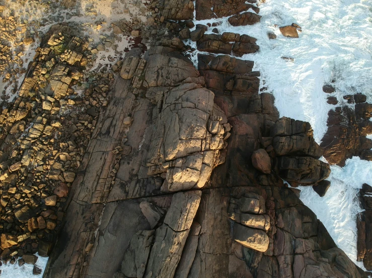 a sea shore covered in rocks and ocean foam