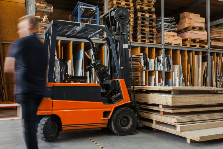 a forklift with lots of stacked wood