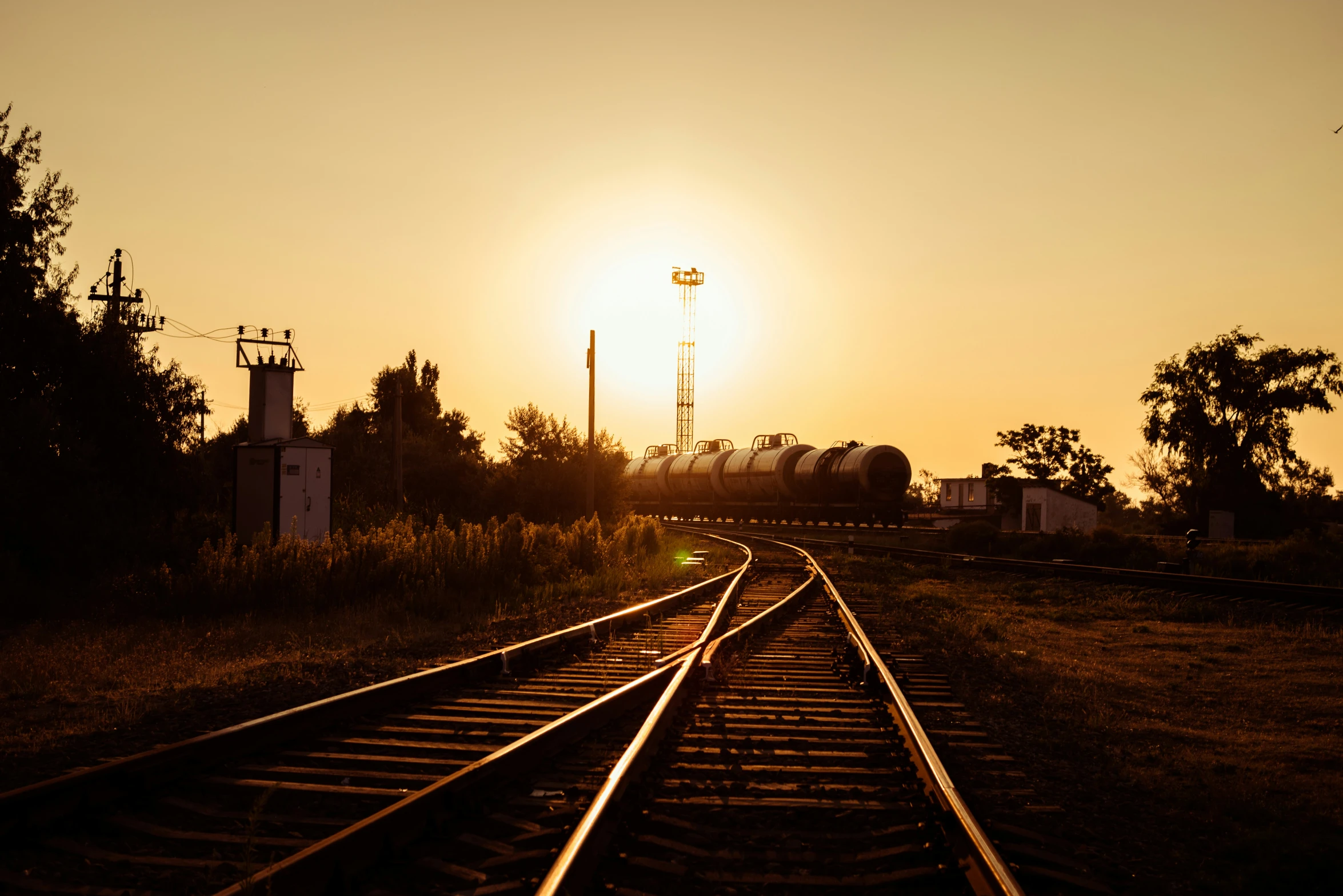 the sun is setting over train tracks in the countryside