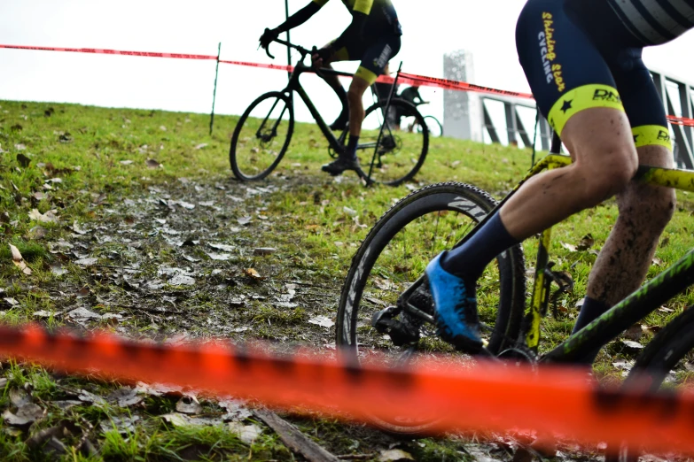 people riding bikes on the side of a green hillside