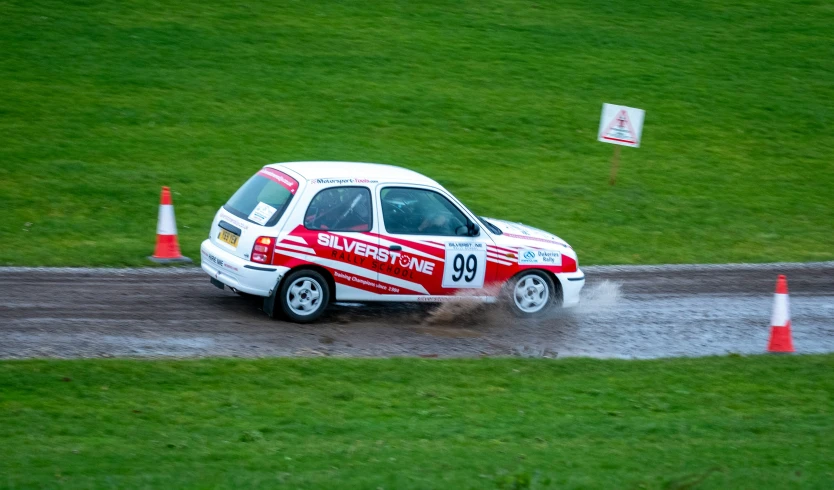 small red and white vehicle turning into dirt