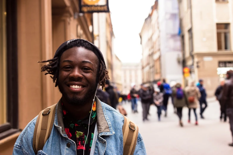 a man with dreadlocks walking down a street