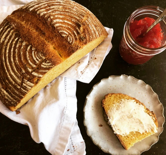 loaf of bread and fresh fruit sitting on a white plate