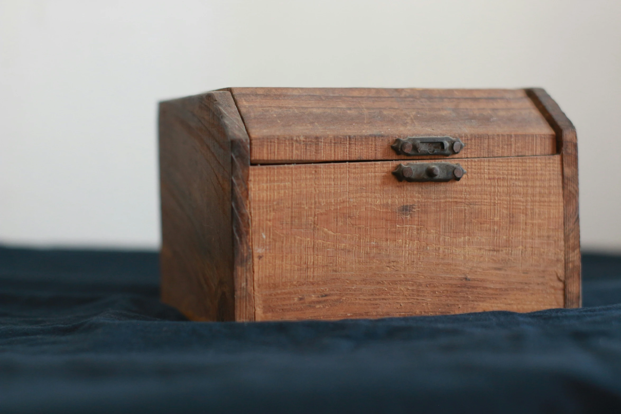 a small wooden chest on top of a bed