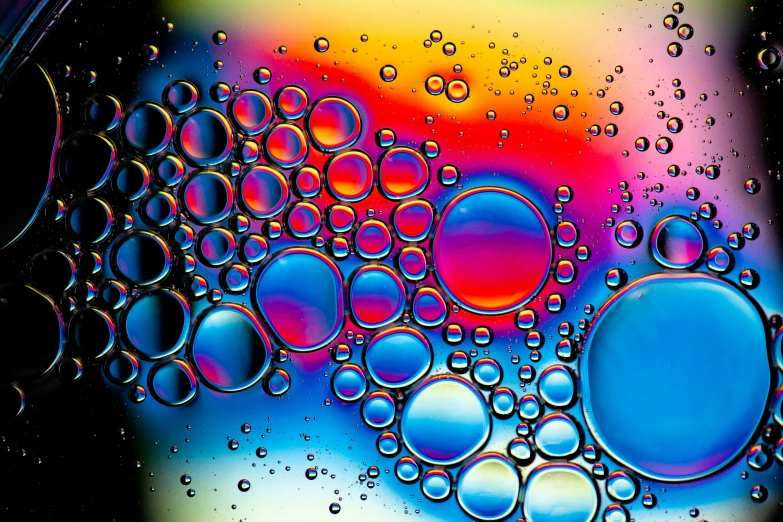 a pograph of water droplets in liquid with colored background