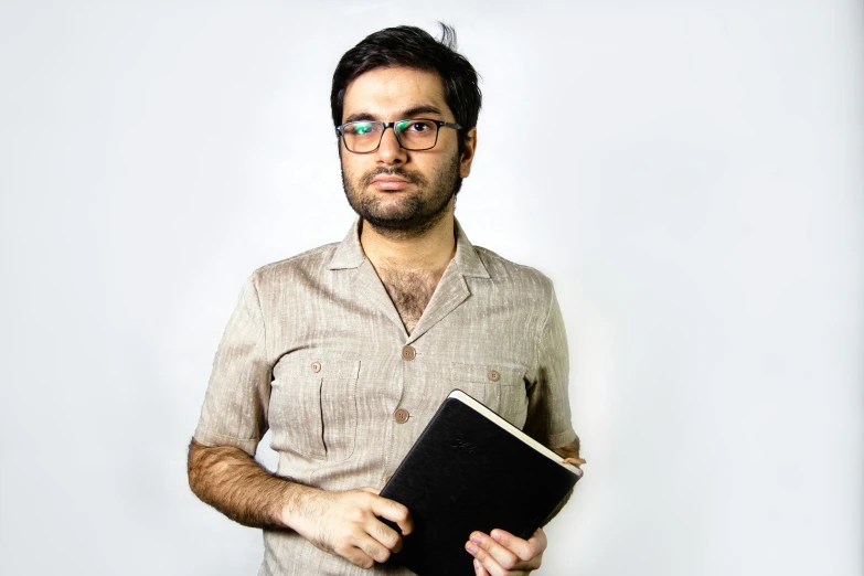 a man is holding his bible while wearing glasses