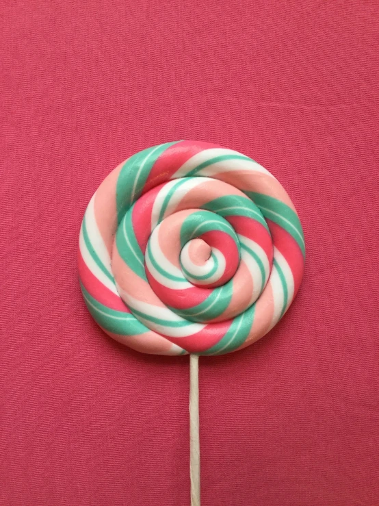 candy cane sitting on top of a pink surface