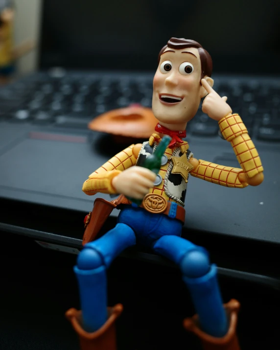 a toy character is sitting on a keyboard