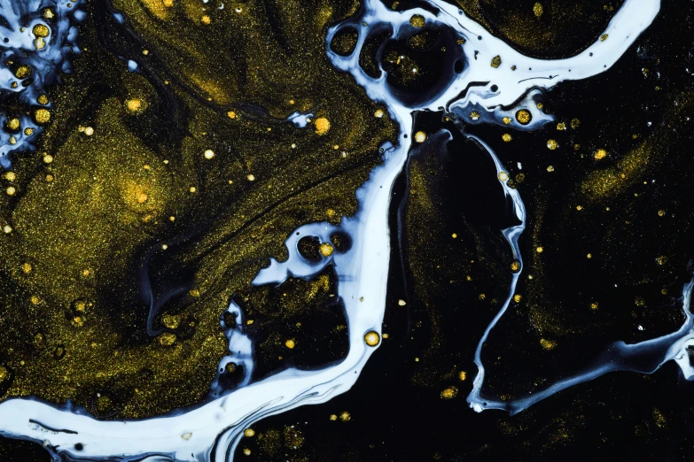 a mixture of water and gold on a black background