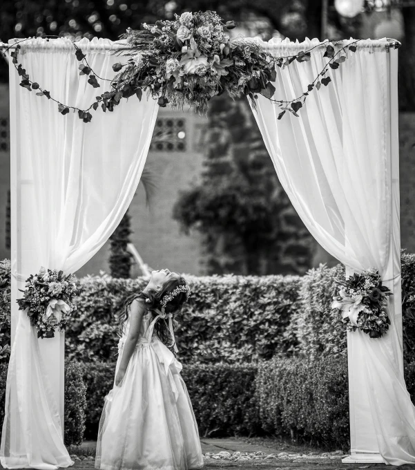 black and white pograph of a wedding in front of a flower trellis