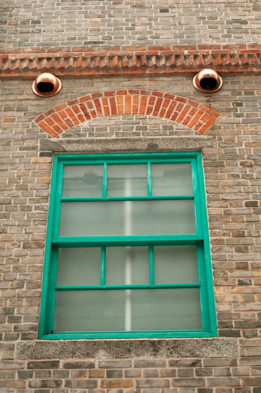 an arched window with a window pane in between it and some bricks