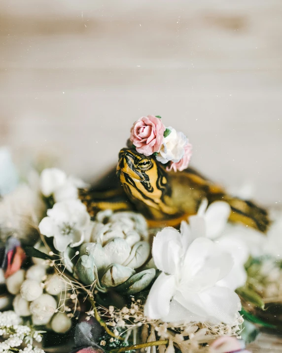 floral arrangement with flower and ceramic bird on top