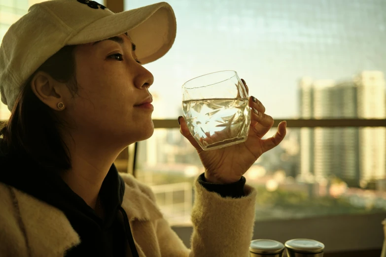 a woman holding a glass filled with water