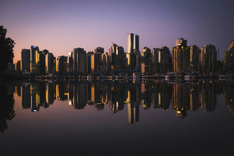 a city is seen with it's skyscrs reflected in the water