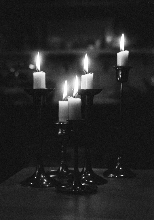 several white lit candles on a wooden table