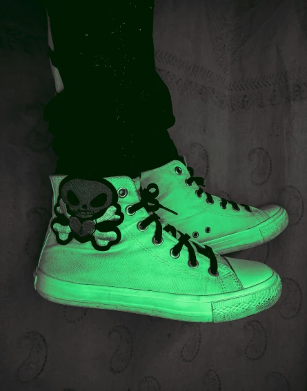 an glow - in - the - dark pair of shoes on top of a bed