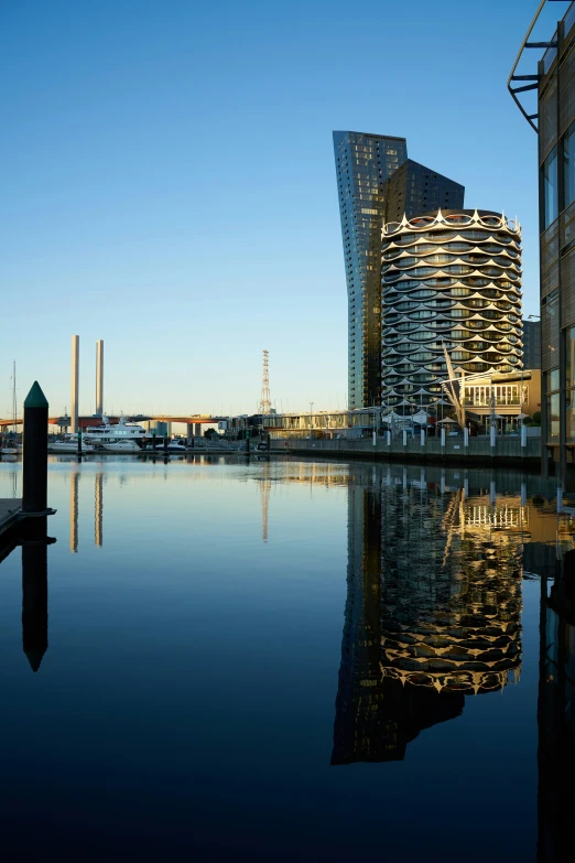 the reflections of buildings and boats on a large body of water