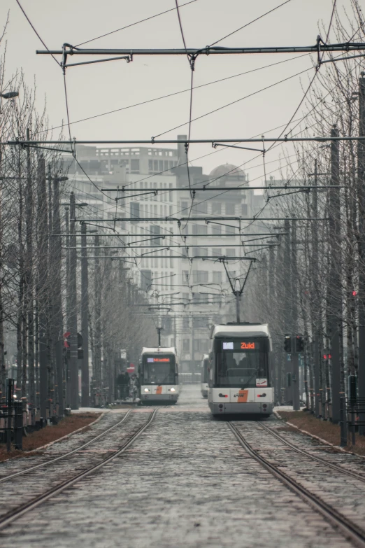 commuter trains on a road with buildings in the background