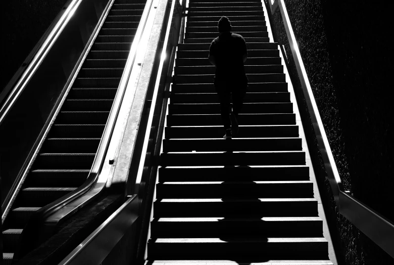 a man in black is walking up some stairs