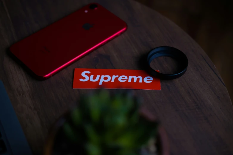a red phone and a couple of red scissors are lying on a table