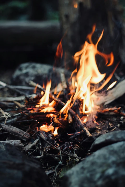 the fire is lit up near the rocks