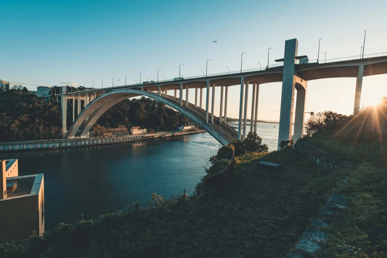 an image of a bridge over water during sunset