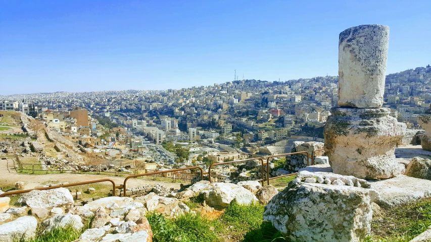 ruins and rocks sit in the foreground of a city