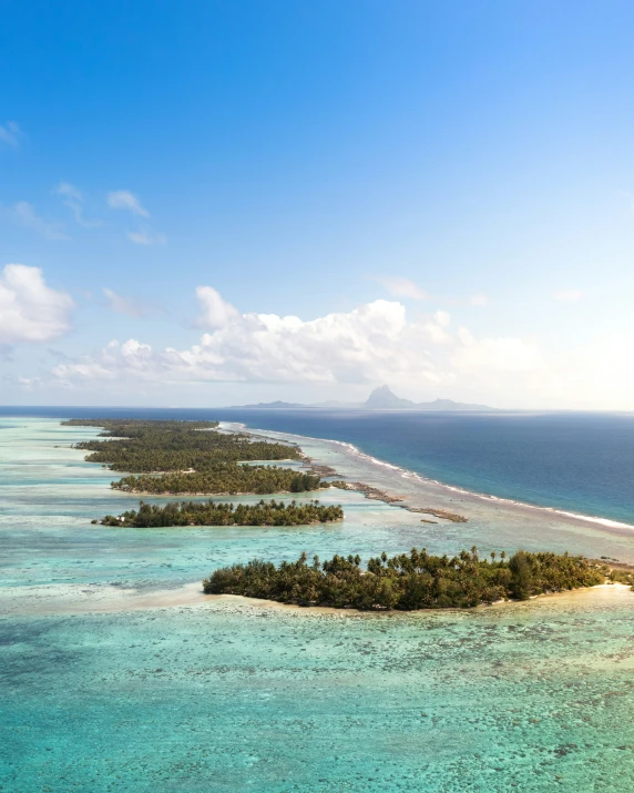 three tropical islands sitting off in the middle of ocean