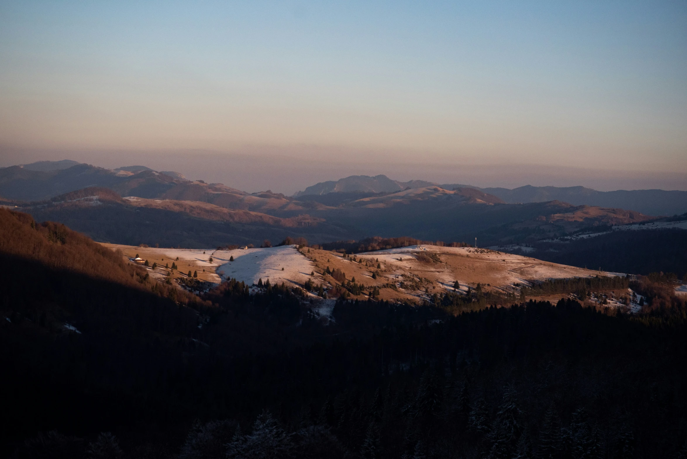 the view from the top of a hill, with snow on the ground