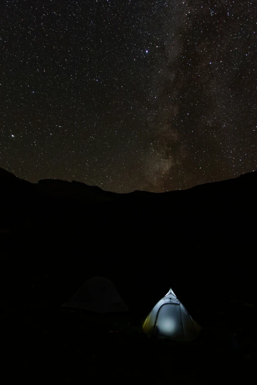 the dark sky with stars above a tent