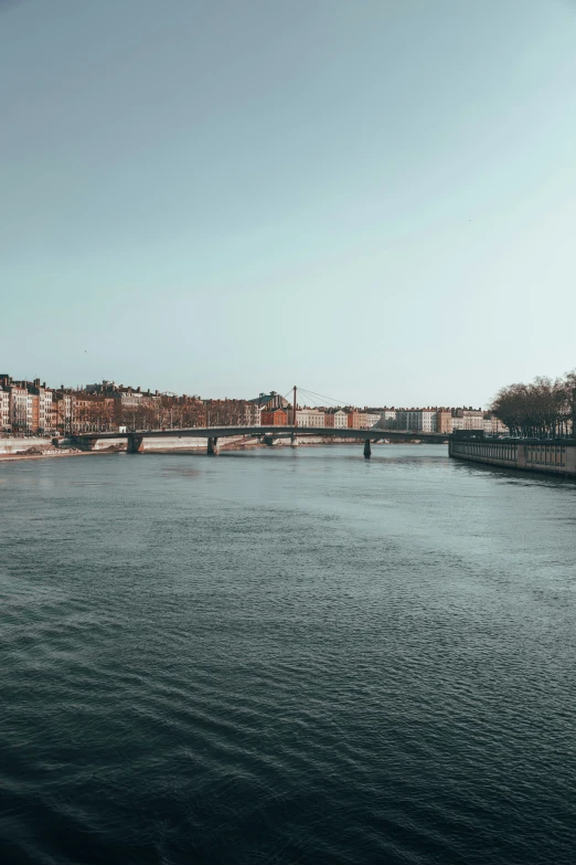 a long narrow body of water with bridge in the background