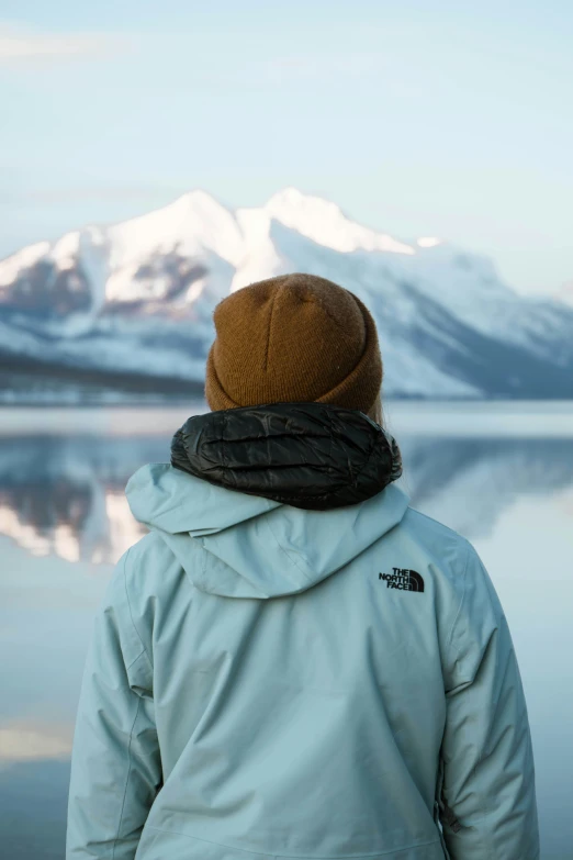 a person standing with their back to the camera wearing a hat and jacket