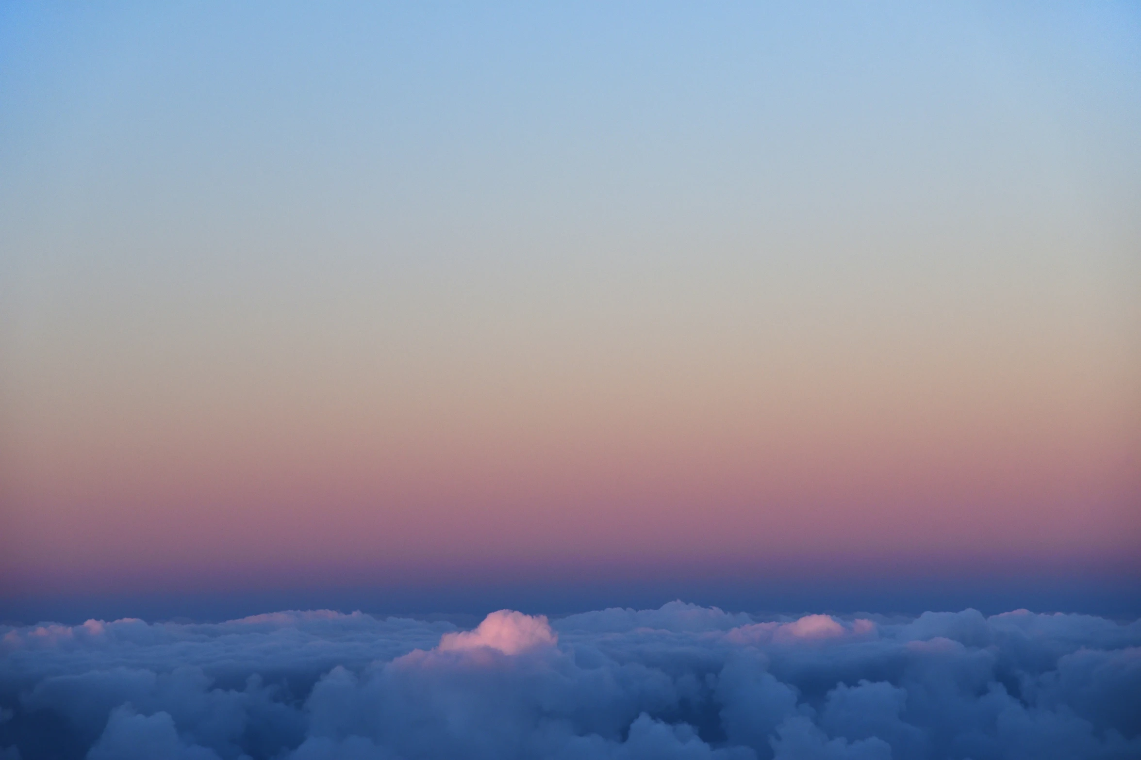 a large jetliner flying above a cloud covered sky