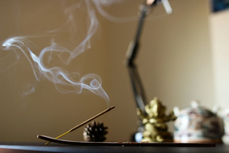 smoke is coming from incense sticks and on a small table