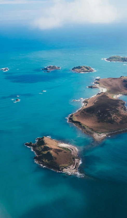 an island is surrounded by turquoise water and land