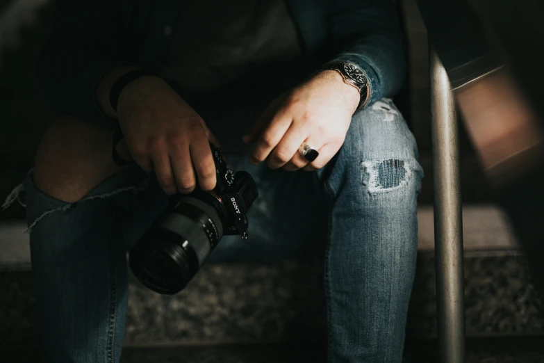 the person is sitting in a chair holding a camera