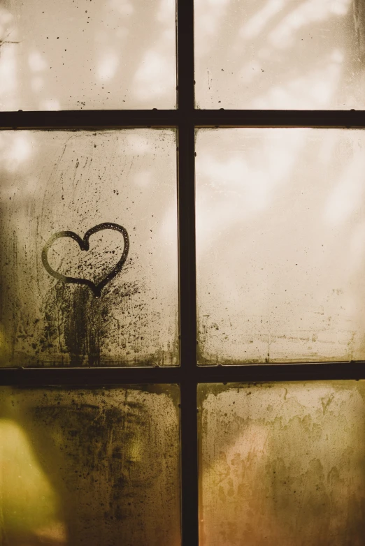 the window is dirty and has a heart drawn on it