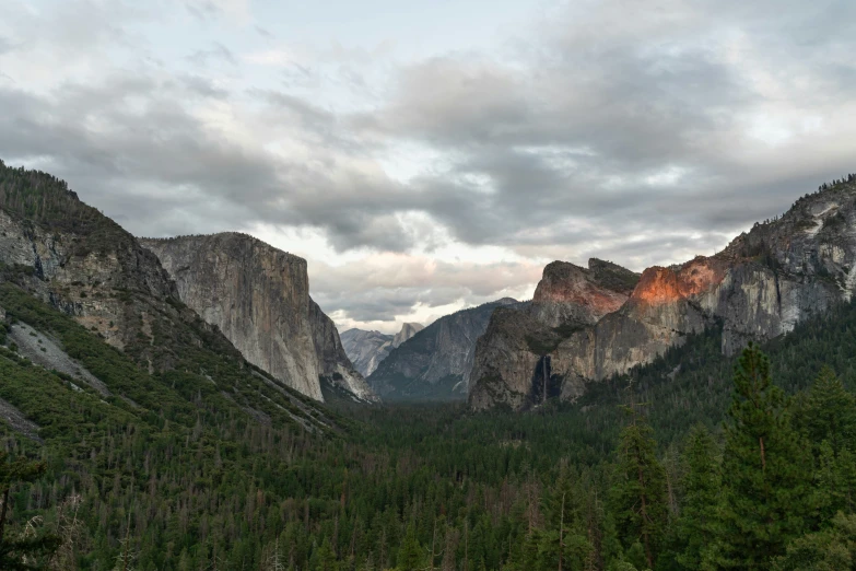 a view of a valley near mountains and trees